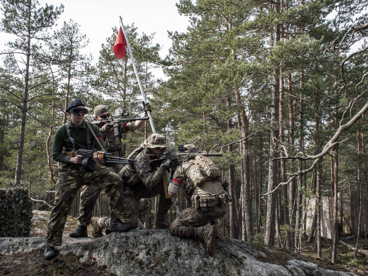 Joukkue lipun luona metsässä